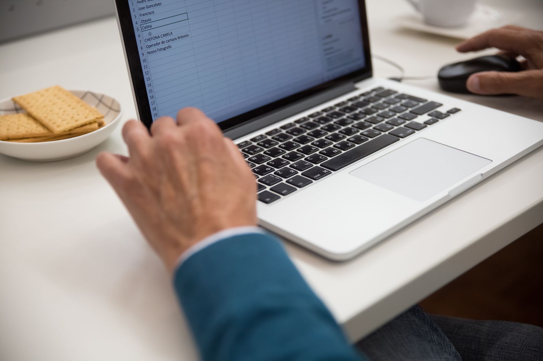 Professional reviewing digital spreadsheets and reports on a keyboard